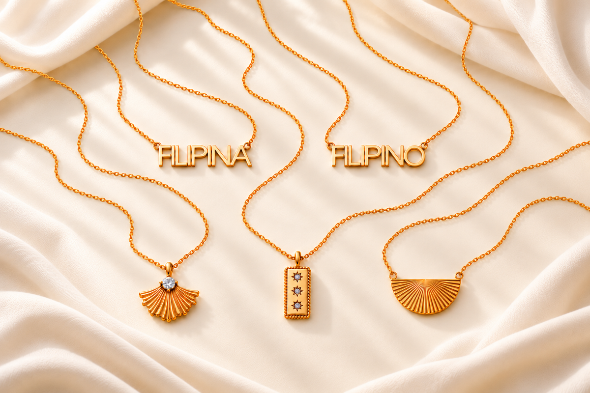 FILIPINA and FILIPINO above PINAS, LUZVIMINDA and PAM gold necklaces styled with flowing chains on ivory