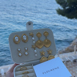 FLEURENZ shell and pearl jewelry in a travel case overlooking the ocean